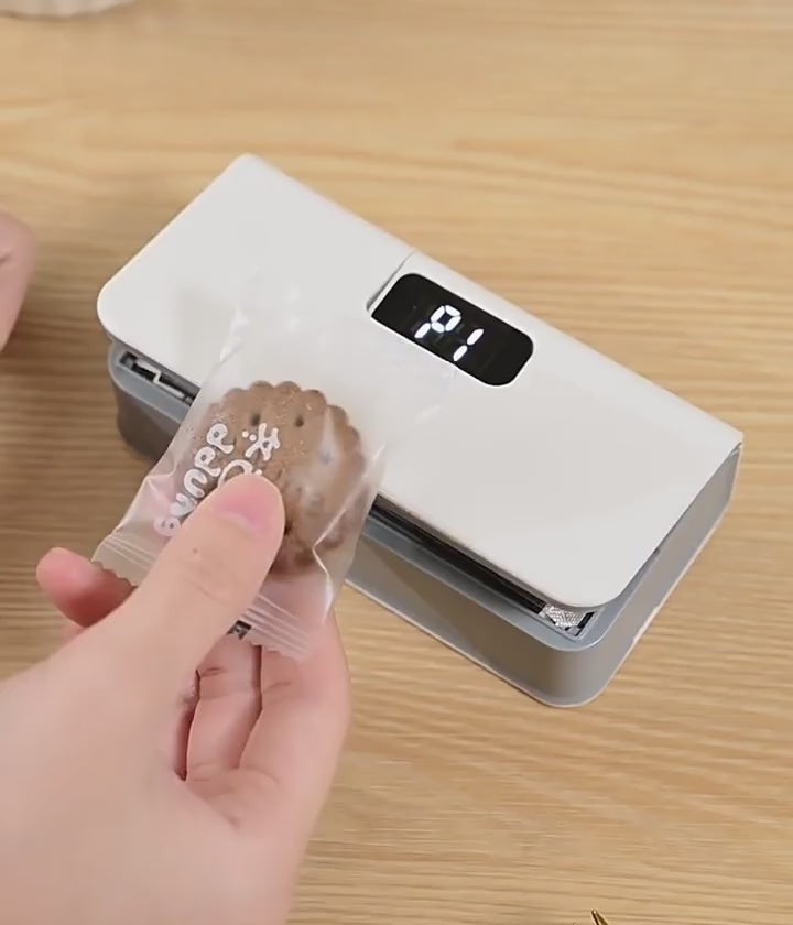 Pressing the sealer on a clear bag while it counts down, then showing the sealed bag